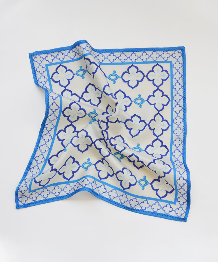 Blue and white patterned square scarf on a white background