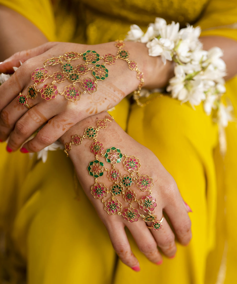 Model wearing pink enamel hathphool flower motif adjustable chain bracelet from gul collection.