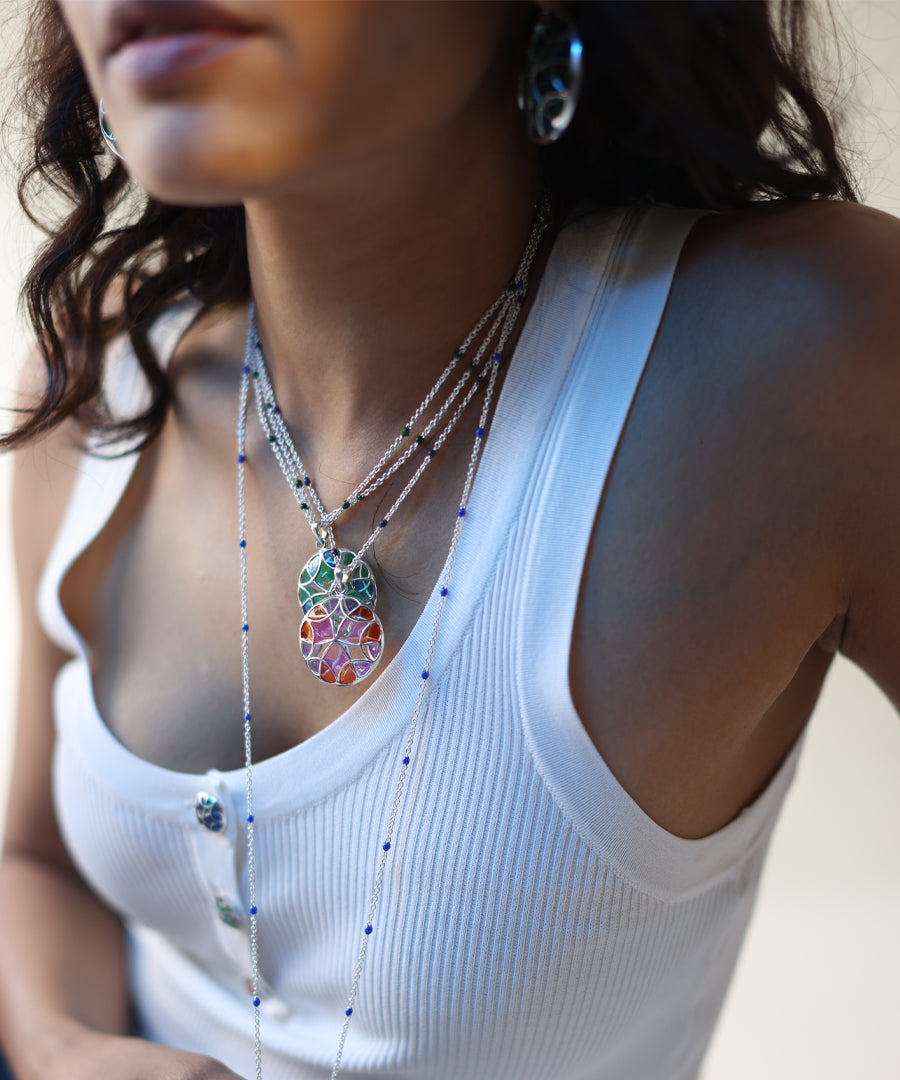 Model wearing rust pink and rama green silver long necklace with enamel work.