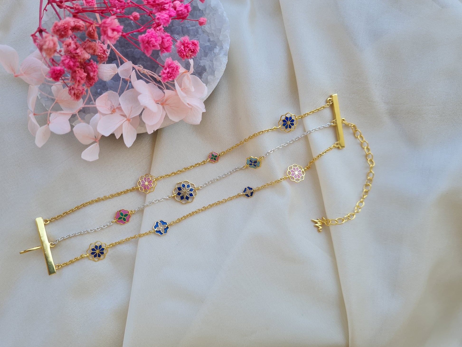 Adjustable designer chain bracelet with flower motifs crafted in silver with gold plating.