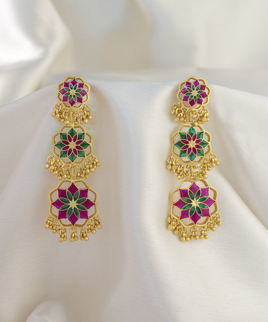 Rani pink colored earrings lying on silk cloth. 92.5% sterling silver earrings from gulaal collection by Manner India.